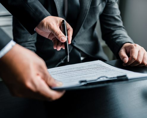 Close Up Of Businessmen Or Lawyers Discussing Contract Or Business Agreement At Law Firm Office